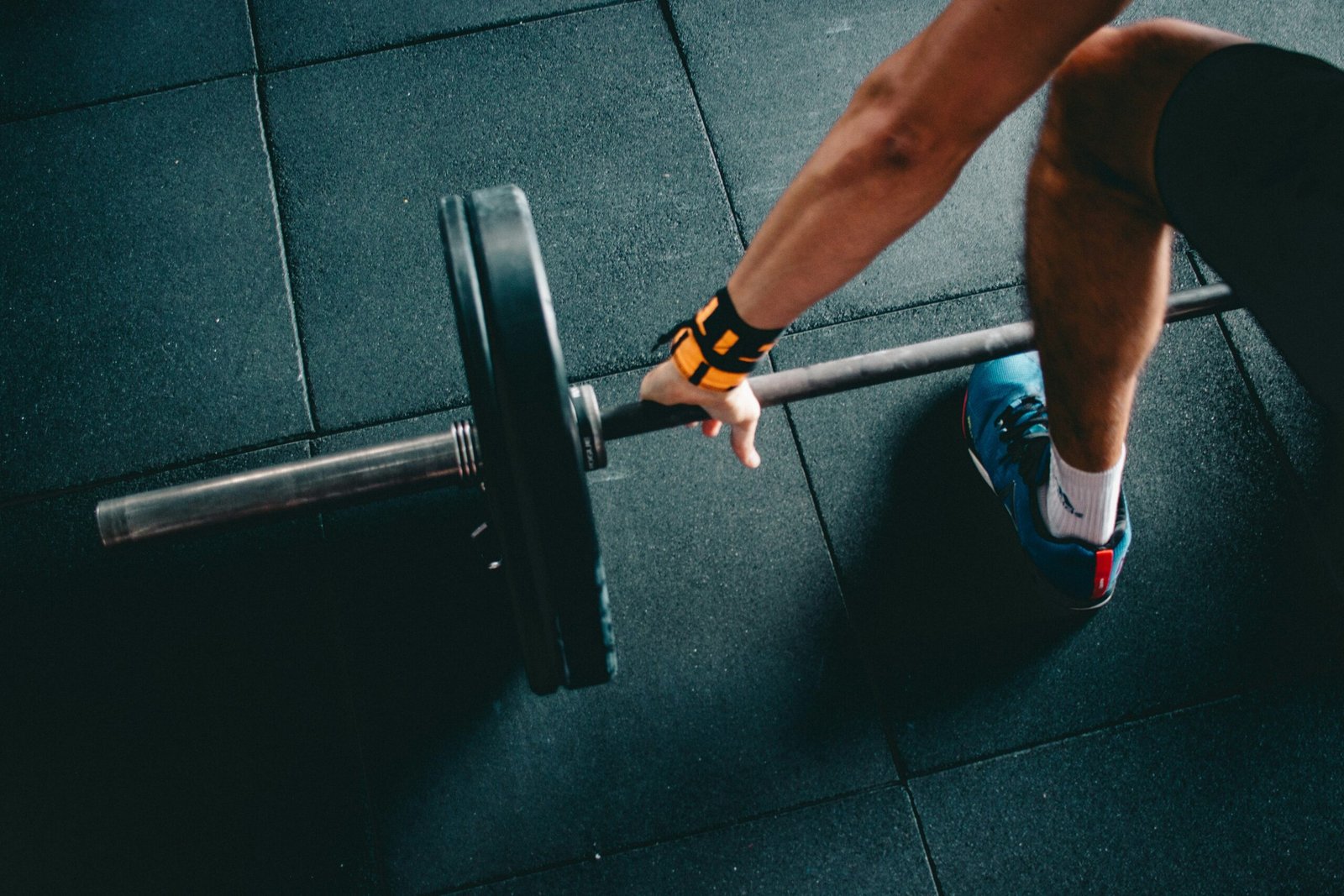Person lifting a barbell during a strength training workout in a gym.