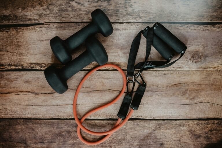 Dumbbells and resistance bands placed on a wooden surface