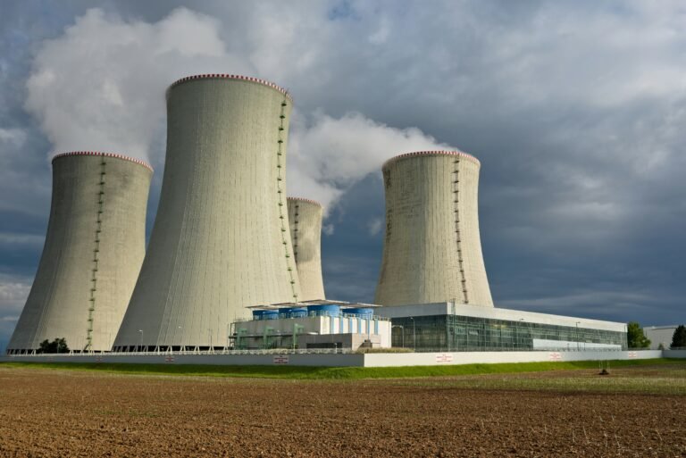 A nuclear power plant with large cooling towers under a cloudy sky