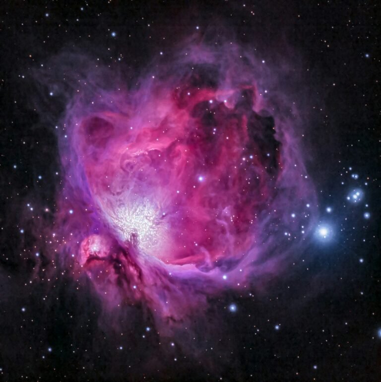 A colorful pink and purple nebula surrounded by stars in outer space