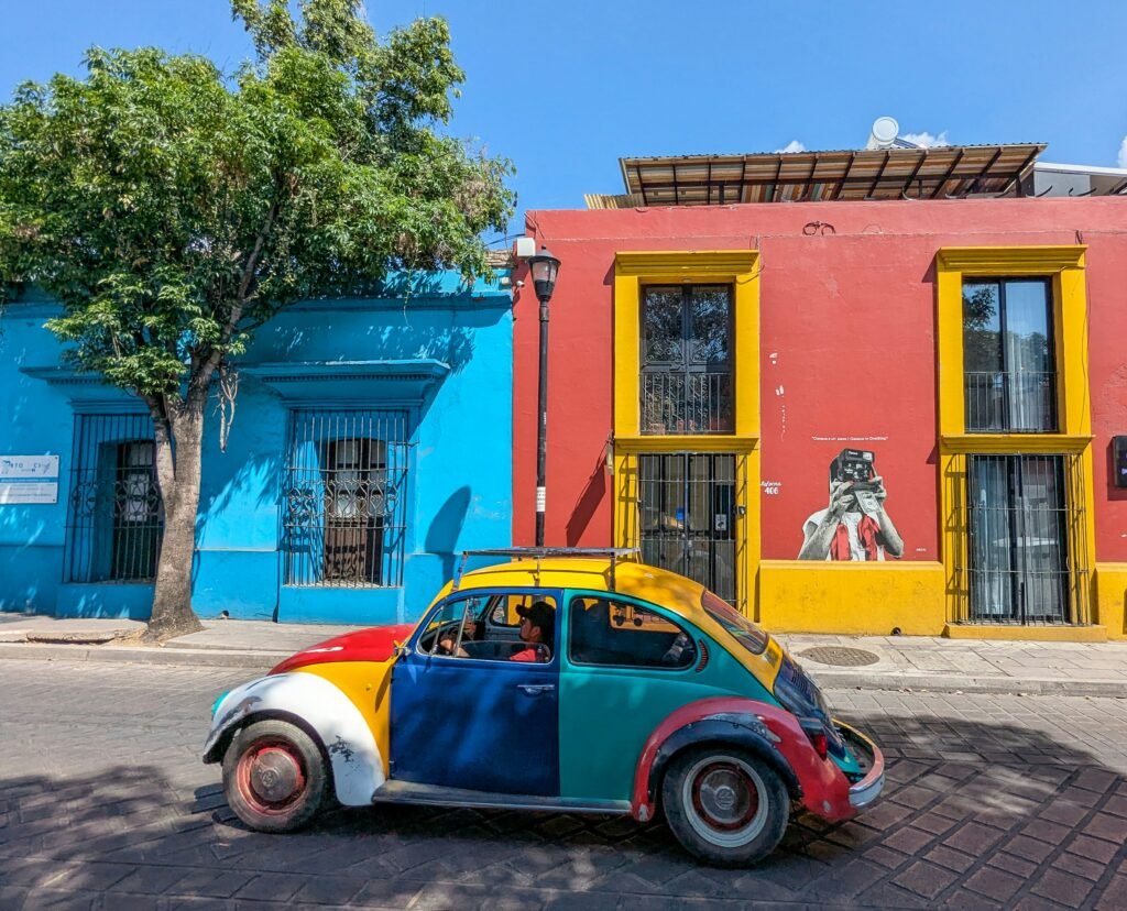 Brightly colored buildings and VW Bug in a vibrant European city under a clear blue sky.
Photo Credit: Bob Brewer