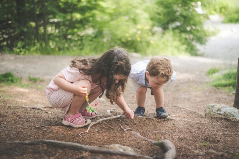 Two young children exploring nature together outdoors