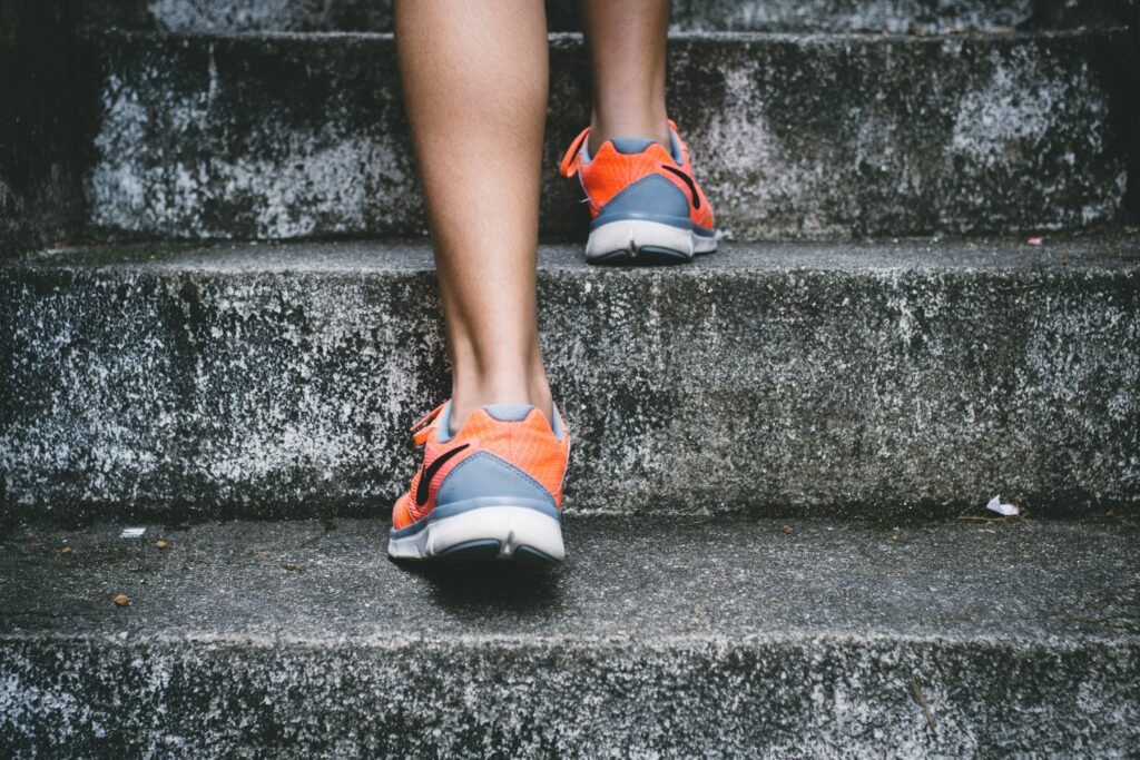 Person walking up concrete stairs during exercise to improve health and fitness.