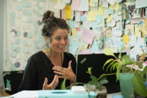 Anna from Teachers Planit, an Instructional coach speaking with a teacher in a creative classroom workspace