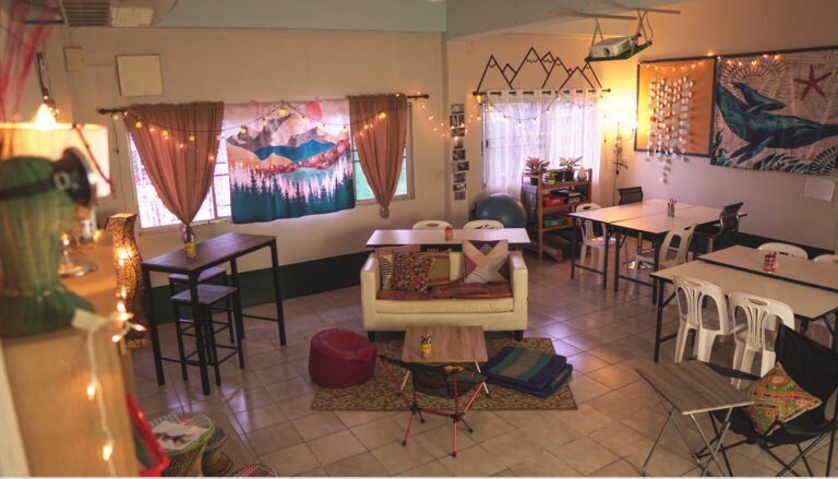 Classroom redesigned with alternative seating — a loveseat, bean bag chair, camping chairs, and string lights instead of traditional desks
