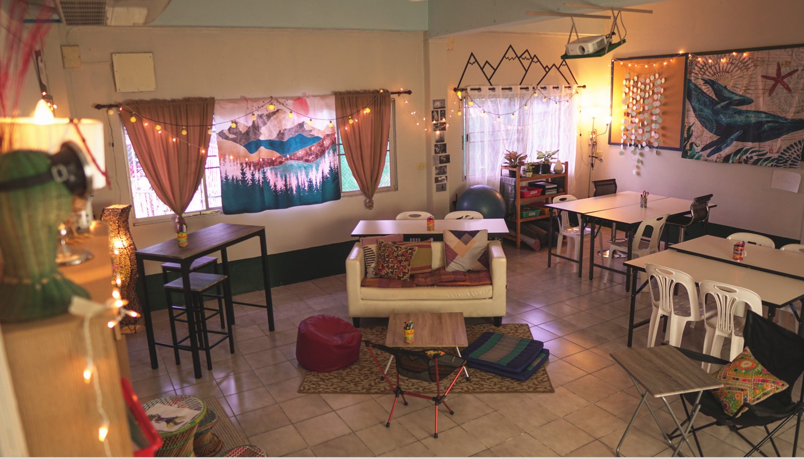 Classroom redesigned with alternative seating — a loveseat, bean bag chair, camping chairs, and string lights instead of traditional desks