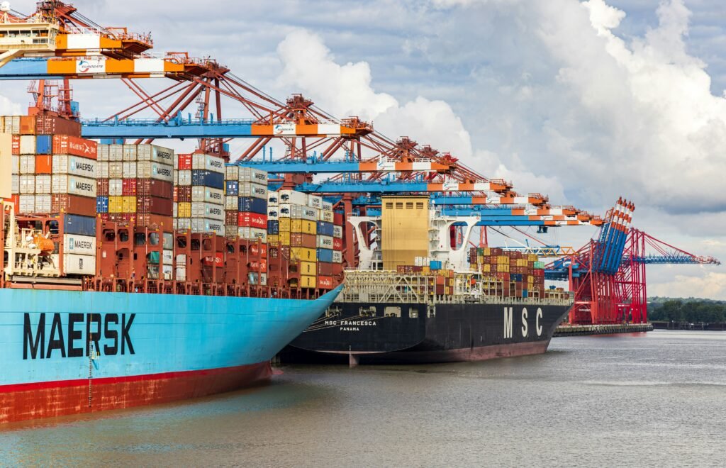 Cargo ships loaded with shipping containers at a busy commercial port