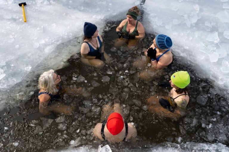People taking an ice bath in a frozen lake