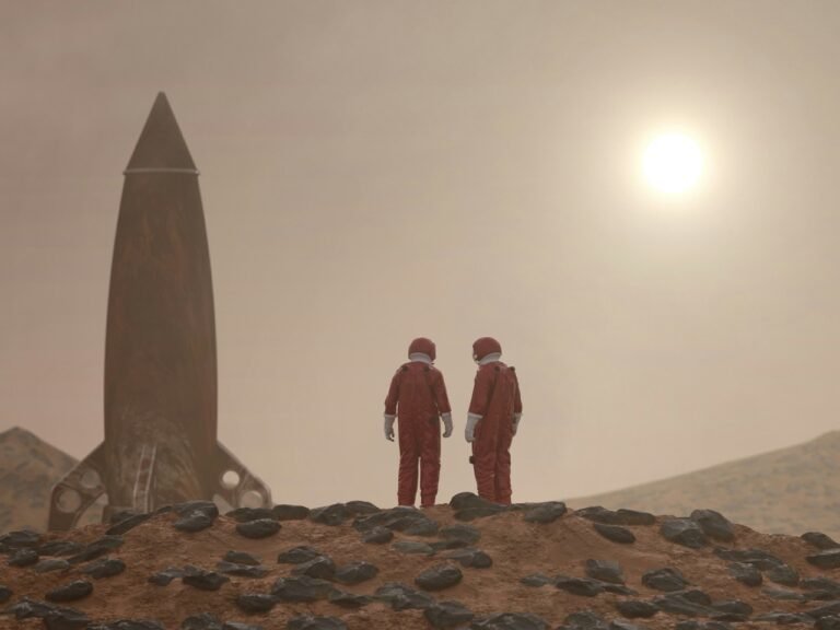 Two astronauts in red spacesuits standing on a rocky red planet surface near a rocket