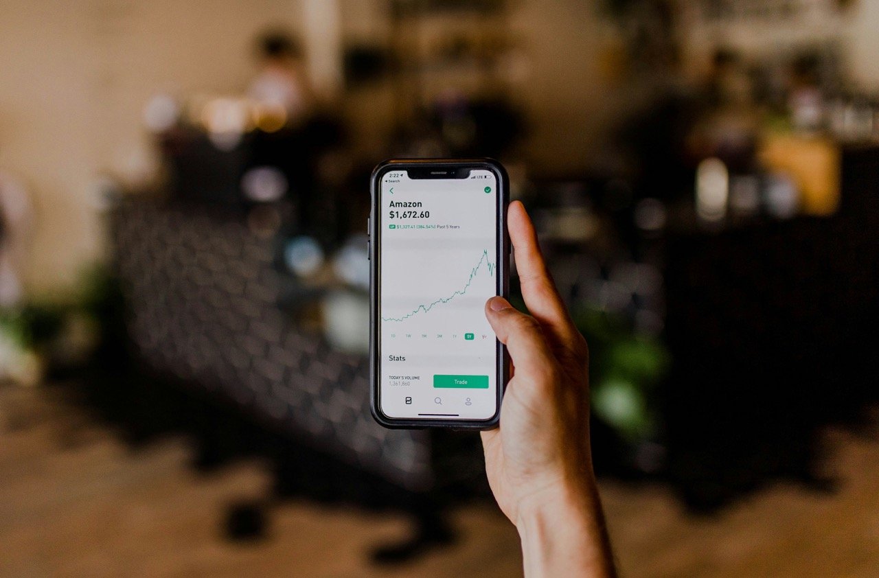 Person checking a stock market chart on a smartphone