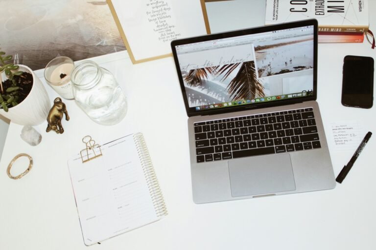 Laptop and travel planning materials on a desk