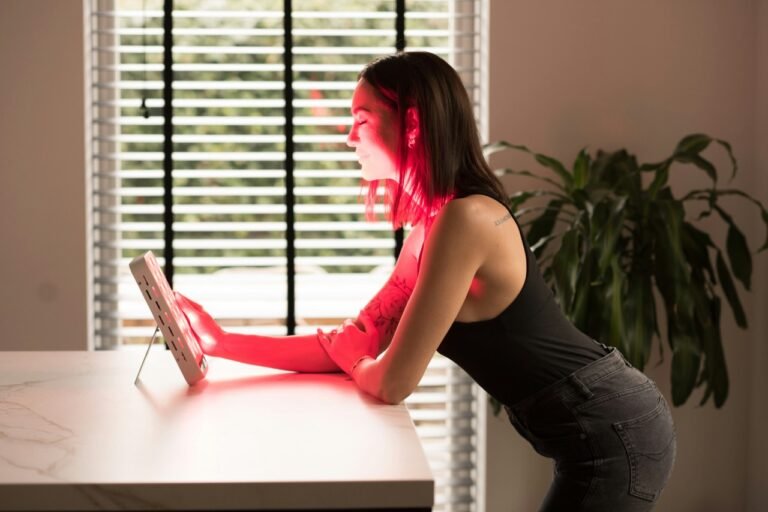 Woman using a red light therapy device at home