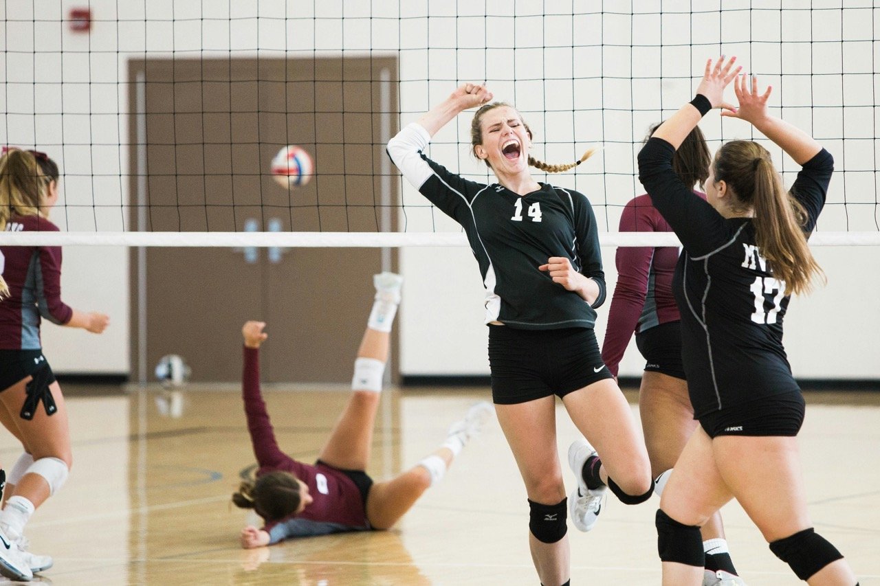 Youth volleyball players competing during a match
