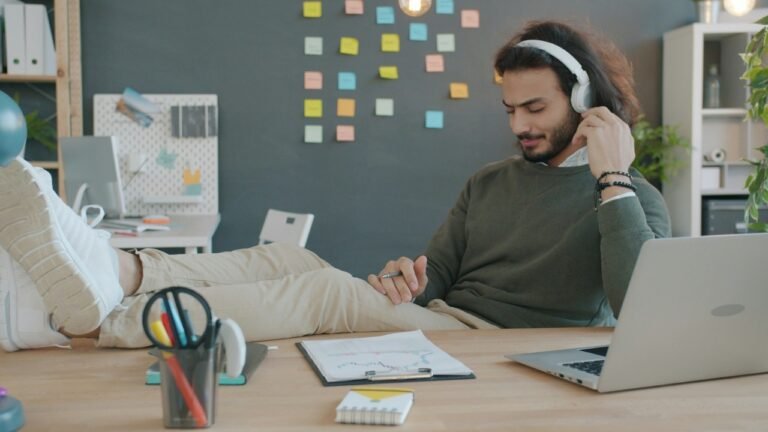 Man working at a desk with headphones and a laptop