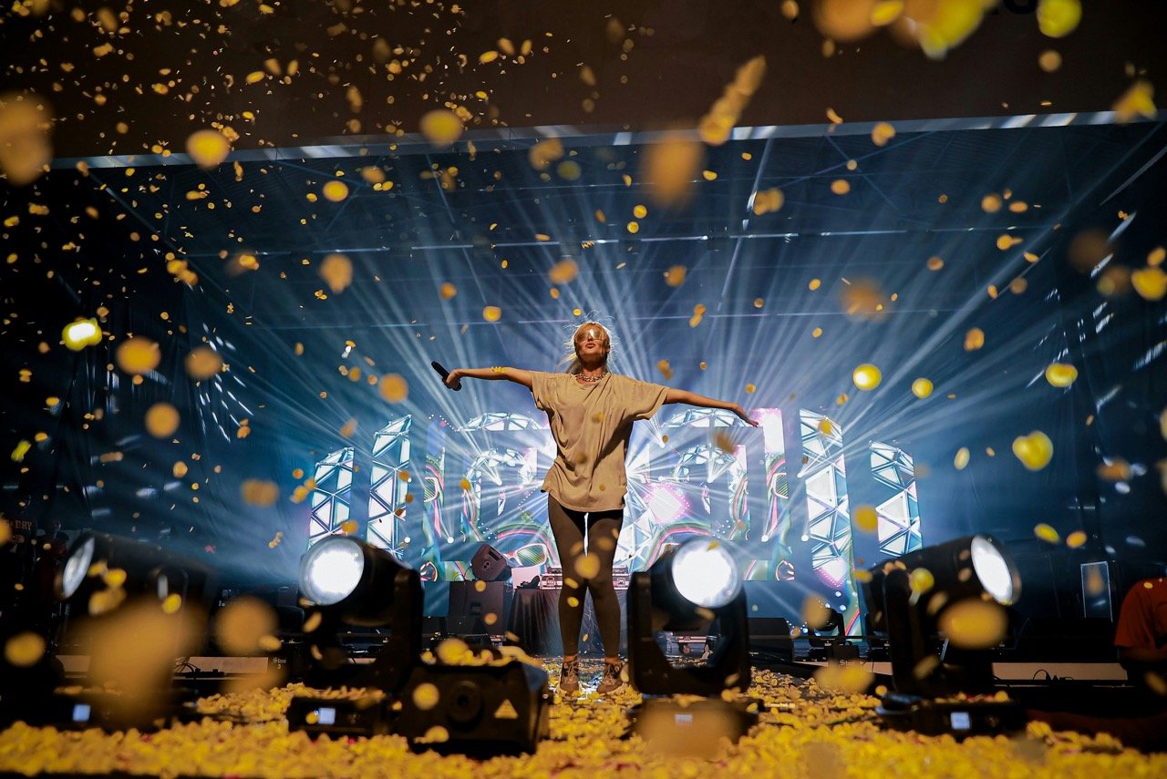 Singer performing on stage as confetti falls during a live concert