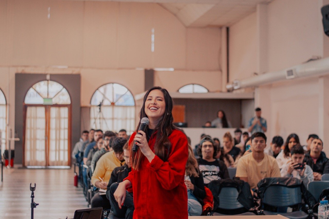 Woman speaking confidently into a microphone in front of an audience