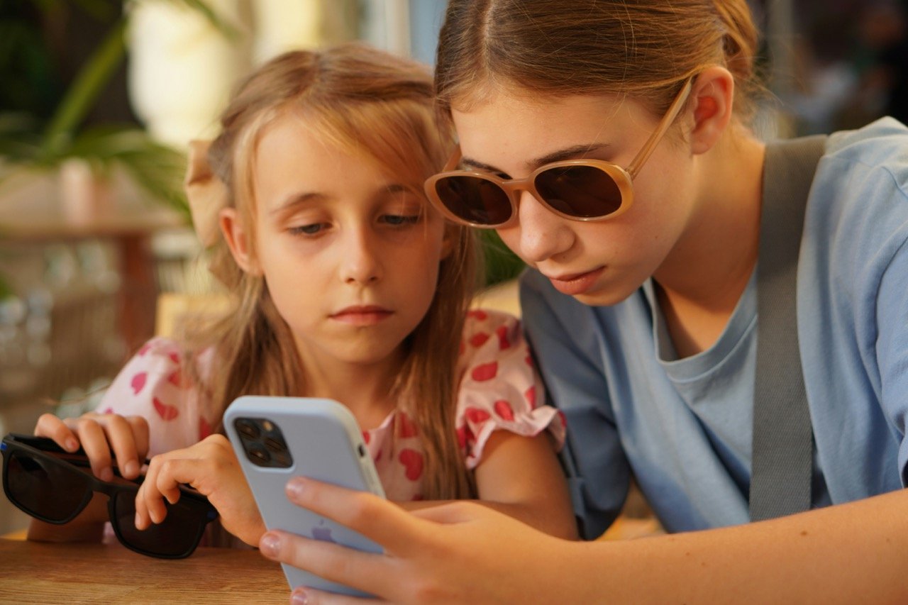 Two teenage girls looking at a smartphone together